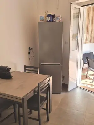 a kitchen with a table and a refrigerator at Pigneto Giardino e Posto Auto Privati in Rome