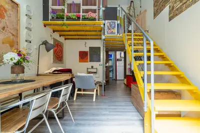 a room with a yellow staircase and a table and chairs at Rossana Urban Style Loft close to Termini Station in Rome
