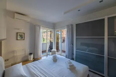 a bedroom with a white bed and a large window at Villa Ada Apartment - Parioli in Rome