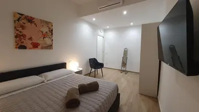 a bedroom with a bed and a flat screen tv at MariElu a Trastevere in Rome