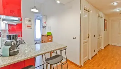 a kitchen with a counter and stools in a room at Saint Bon Apartment Good for Families in Rome
