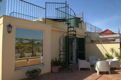 a patio with white chairs and a staircase on a house at La Dolce Vista in Rome