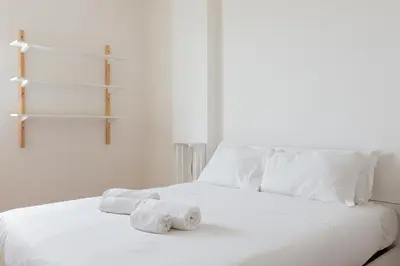 a white bed with two rolls of towels on it at Agostini 9- Bright Flat in Rome