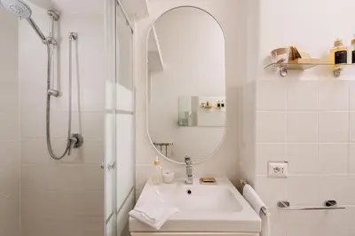 a white bathroom with a sink and a mirror at Santamato Vatican Apartment in Rome