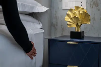 a person standing next to a bed with a trophy on a night stand at 69 Suite Boutique in Rome