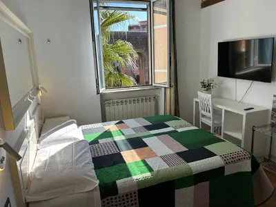 a bedroom with a bed and a table and a window at Villa Lanusei in Rome