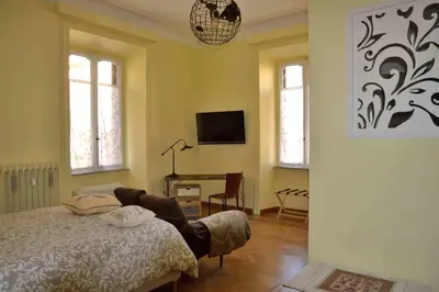 a bedroom with a bed and a desk and windows at Trastevere elegant apartment in Rome
