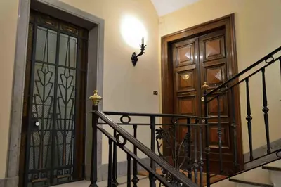 a hallway with two wooden doors and a staircase at Trastevere elegant apartment in Rome