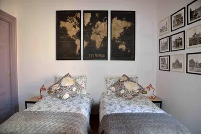 two beds in a room with maps on the wall at Trastevere elegant apartment in Rome