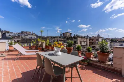 a table and chairs on a roof with a view of a city at Attic with terrace Spanish Steps exclusive in Rome