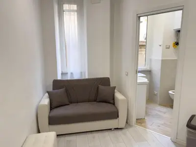 a chair sitting in a room with a bathroom at Valerias Nest Elegant Apt with WiFi and Charm in Rome