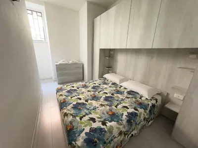 a bedroom with a bed with a floral bedspread at Valerias Nest Elegant Apt with WiFi and Charm in Rome