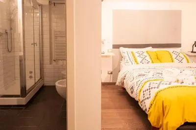 a bedroom with a bed and a bathroom with a shower at Domus Loft Colosseum - Rione Monti in Rome