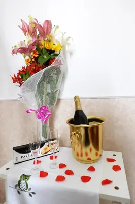 a table with a bottle of champagne and a bucket of flowers at Little House Roma in Rome