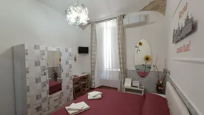a room with a red table and a mirror at Little House Roma in Rome