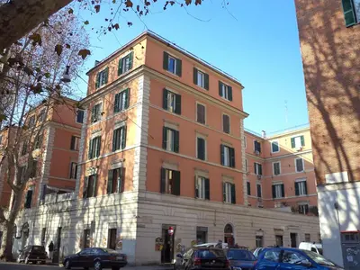 a tall brick building with cars parked in front of it at Little House Roma in Rome