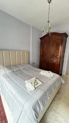 a bedroom with a large bed with a wooden cabinet at Bella Roma Stay in Rome