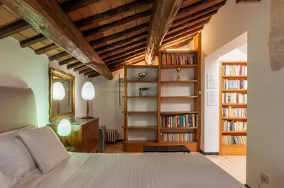 a bedroom with a bed and bookshelves at Orange Room with bathroom and Shared Terrace in Rome