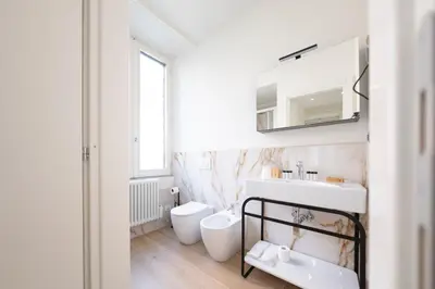 a white bathroom with a sink and a toilet at Domus Giulio Guest House in Rome