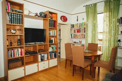 a living room with a dining room table and book shelves at La Casetta del '32 in Rome