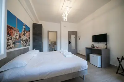 a bedroom with a white bed and a flat screen tv at Domus Garbatella in Rome
