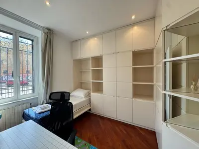 a bedroom with white cabinets and a bed and a window at St John Apartment in Rome in Rome