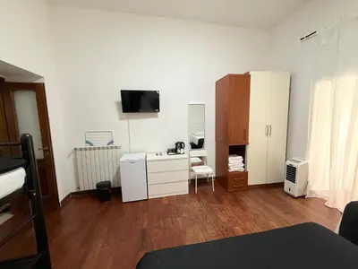 a white room with a desk and a tv on the wall at Roma Comfort Inn in Rome