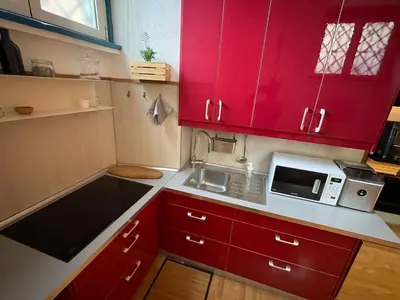 a small kitchen with red cabinets and a microwave at AT Simone Cavallini in Rome