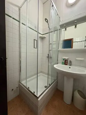 a bathroom with a glass shower and a sink at TatyHouse in Rome