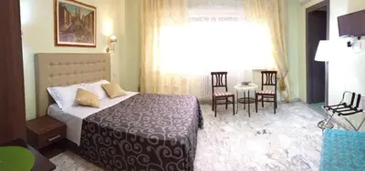 a bedroom with a bed and a table and chairs at Vatican Golden Rooms in Rome