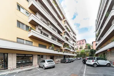 a parking lot in front of a building with cars parked at Vatican Golden Rooms in Rome
