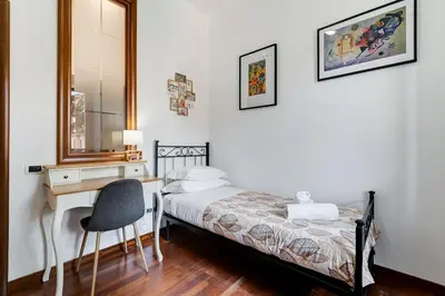 a bedroom with a bed and a desk and a mirror at Villa Riccio-Flaminio House in Rome