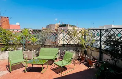 two green chairs and a table on a patio at Pinuz Guest House in Rome
