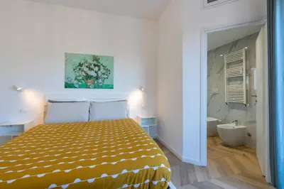 a bedroom with a bed and a bathroom with a tub at BMGA l Poppy's Home Attic Vaticano in Rome