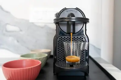 a juicer sitting on a counter with an orange inside at BMGA l Poppy's Home Attic Vaticano in Rome