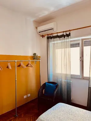a bedroom with a bed and a chair and a window at Trastevere vibes in Rome