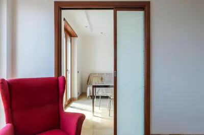 a room with a red chair and a mirror at GuestHost - Bright Apartment in Monteverde in Rome