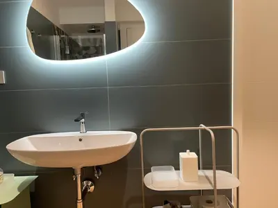 a bathroom with a sink and a mirror at GuestHost - Trastevere Modern Apartment in Rome