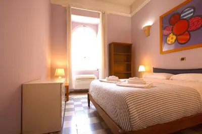 a small bedroom with a bed and a window at Mameli Holiday House in Rome