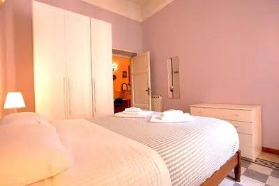 two beds in a bedroom with pink walls at Mameli Holiday House in Rome