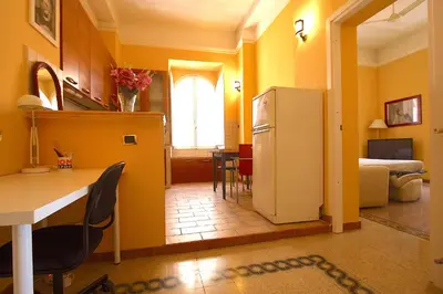 a kitchen and living room with a refrigerator and a table at Mameli Holiday House in Rome