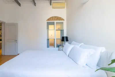a white bedroom with a large white bed with white pillows at Boschetto Apt - Homkeey Apartments in Rome