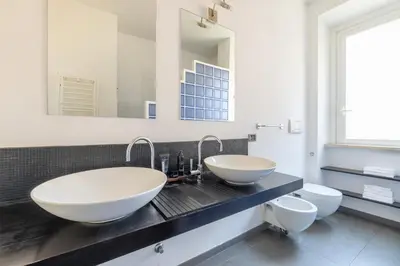 a bathroom with two sinks and two toilets at Boschetto Apt - Homkeey Apartments in Rome