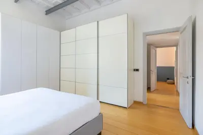 a white bedroom with a large white closet at Boschetto Apt - Homkeey Apartments in Rome