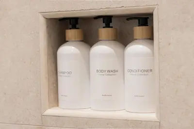 three white bottles in a box on a wall at Luma Rooms in Rome