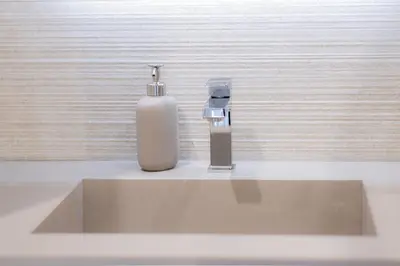 a bottle of soap and a soap dispenser on a sink at Luma Rooms in Rome