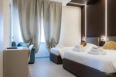 a hotel room with two beds and a window at Luma Rooms in Rome