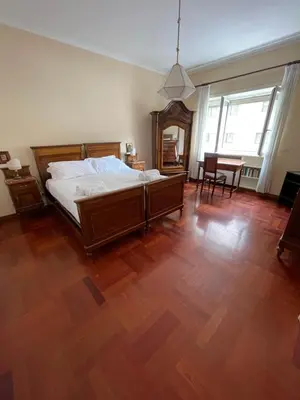 a bedroom with a bed and a wooden floor at Vatican Vibes - 5 minutes from the Pope in Rome