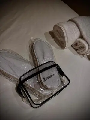 a pair of shoes in a plastic bag on a bed at Apartament Leutari in Rome