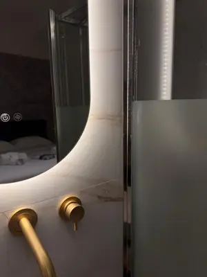 a bathroom with a mirror and a white refrigerator at Apartament Leutari in Rome